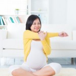Asian pregnant woman yoga at home